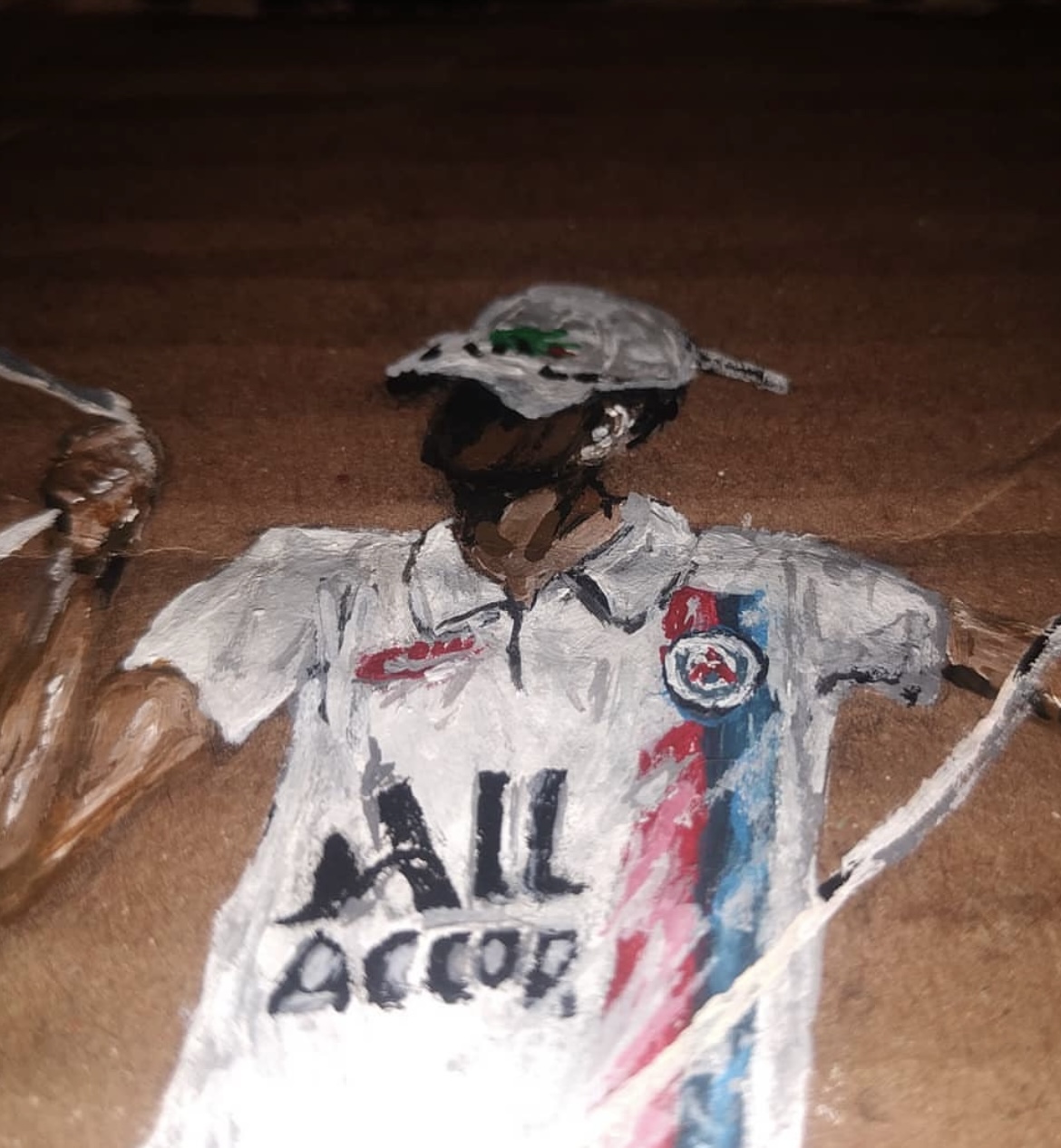 Detalhe da criança com a pipa e a camisa pintada sobre o papelão